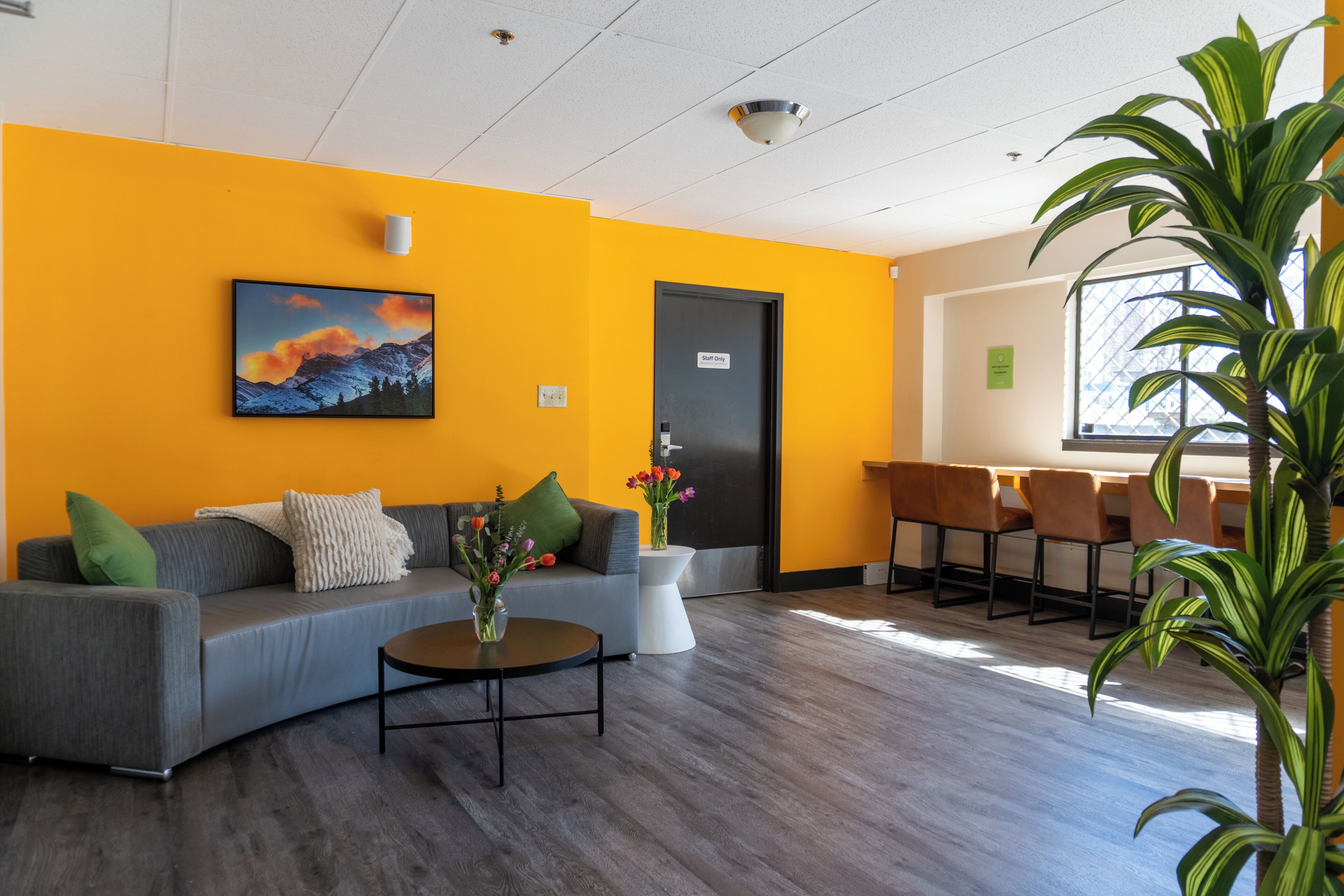 A modern reception area with a sofa, coffee table, and a painting on the wall.