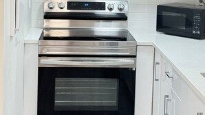 A kitchen with white cabinets, a stainless steel range, an oven, and a microwave. - 🏡 Upscale COZY 2BR Coastal Suite  Private Entry, Laundry & Minutes to the Beach (Surrey)