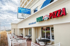 A restaurant named 'ROMA New York Style Pizza' with outdoor seating and a sign for 'Ocean Key Resort' in the background. - 2-bdrm, 2 full bath, kitchen, ocean view unit w/balcony - steps from the beach. (Virginia Beach)