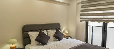 A modern bedroom with a bed, bedside tables, and a ceiling light fixture.