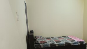 A room with a bed, a ceiling fan, a light fixture, and a marble floor.