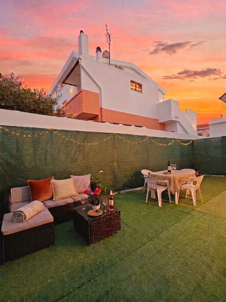 A rooftop terrace with a dining table, chairs, and a sofa set.