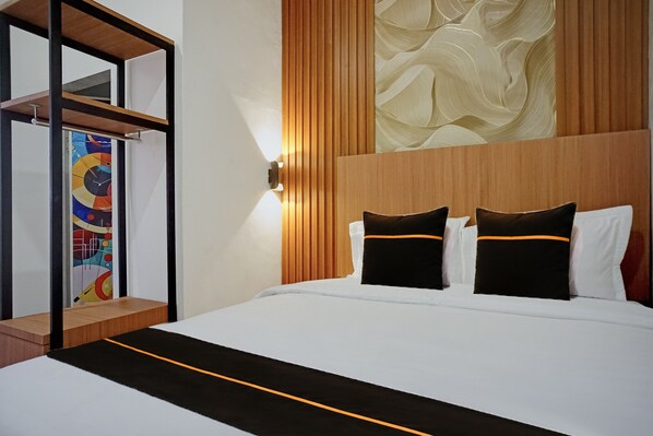 Habitación de hotel con cama, cabecero de madera, lámpara de pared y un cuadro abstracto de colores.