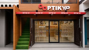 A storefront with a wooden facade and a red awning displaying the sign 'OPTIK VIP'.