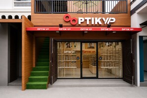 A storefront with a wooden facade and a red awning displaying the sign 'OPTIK VIP'. - Hotel O near Universitas Sumatera Utara  (Medan)
