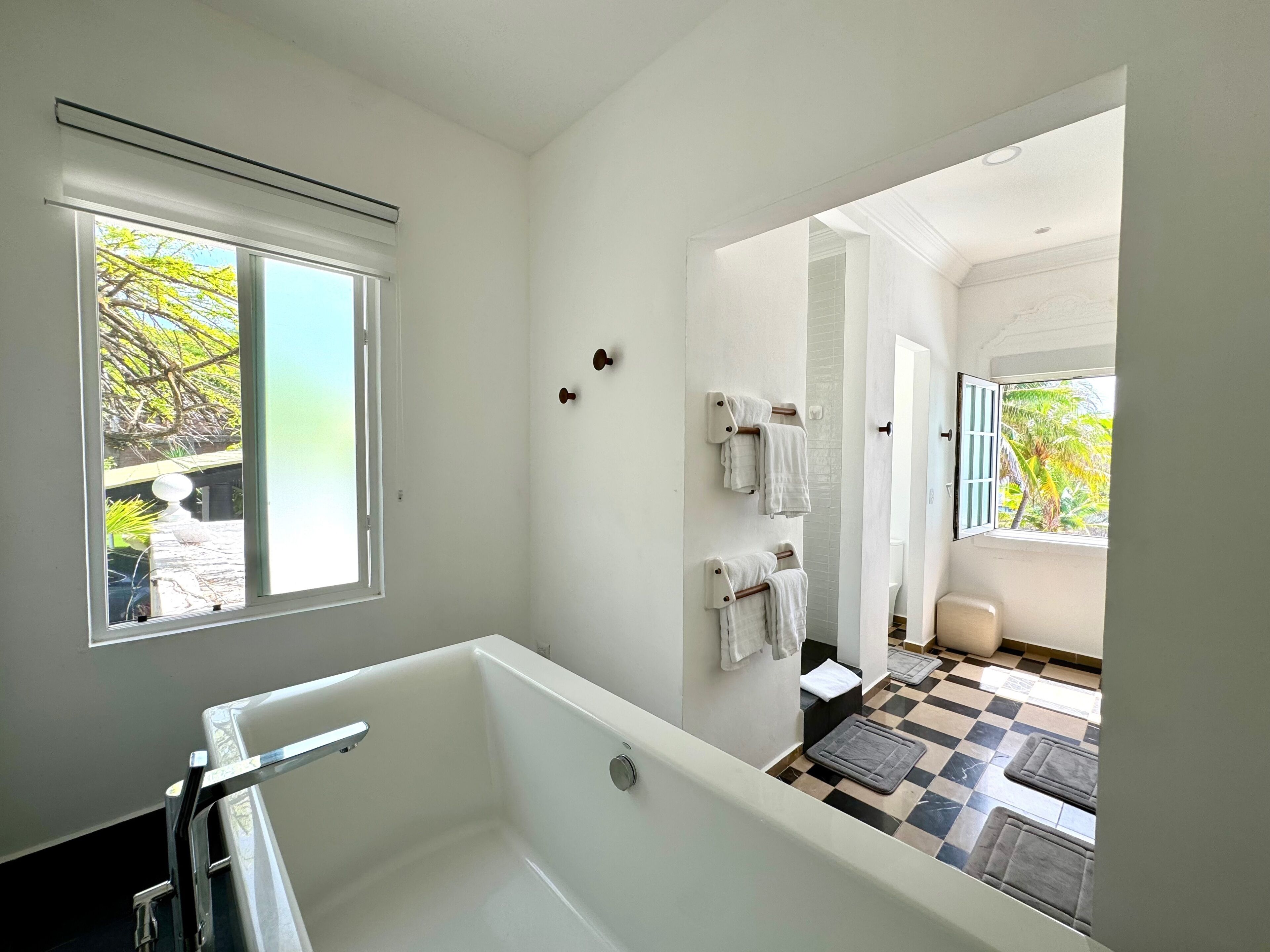 Une salle de bain moderne avec une baignoire, une fenêtre et une vue sur un balcon.