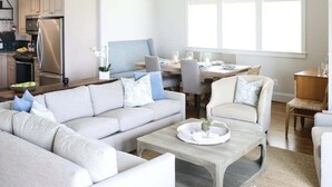 A spacious living room with a sofa, coffee table, and dining area.