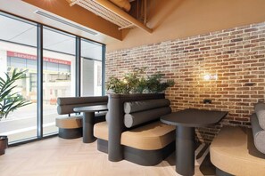 A modern interior with a brick wall, seating arrangements, and a large window. - Apex Executive Apartments- The Ironworks (Dublin)