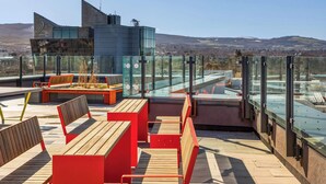 A rooftop terrace with seating, a glass railing, and a view of the landscape. - Apex Executive Apartments- The Ironworks (Dublin)