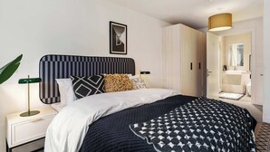 A modern bedroom with a bed, bedside table, lamp, and a view of the bathroom. - Apex Executive Apartments- The Ironworks (Dublin)