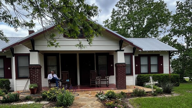 A single-story house with a front porch, a stone pathway leading to the entrance, and a well-maintained lawn.