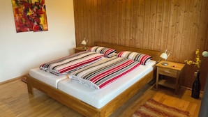 Een slaapkamer met houten lambrisering, een bed, twee nachtkastjes en een nachtkastje.