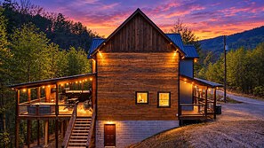 Eine Holzhütte mit Veranda, einer überdachten Terrasse und einer Treppe zum Haupteingang.