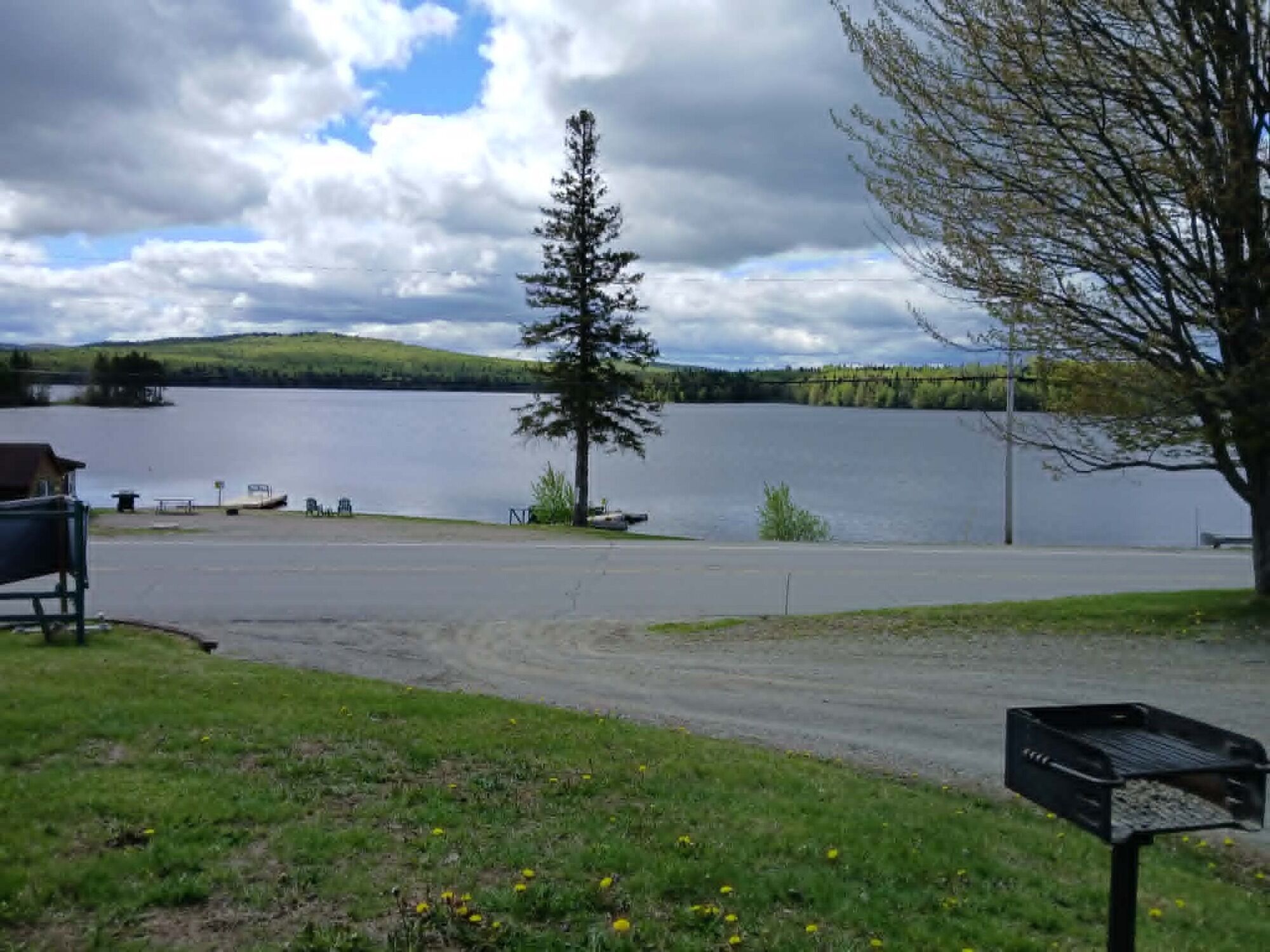 Vista de un lago con un muelle, una banca y un buzón.