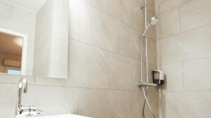 A modern bathroom with a shower, a sink, and a mirror. - Les Loges Du Leman (Crozet)