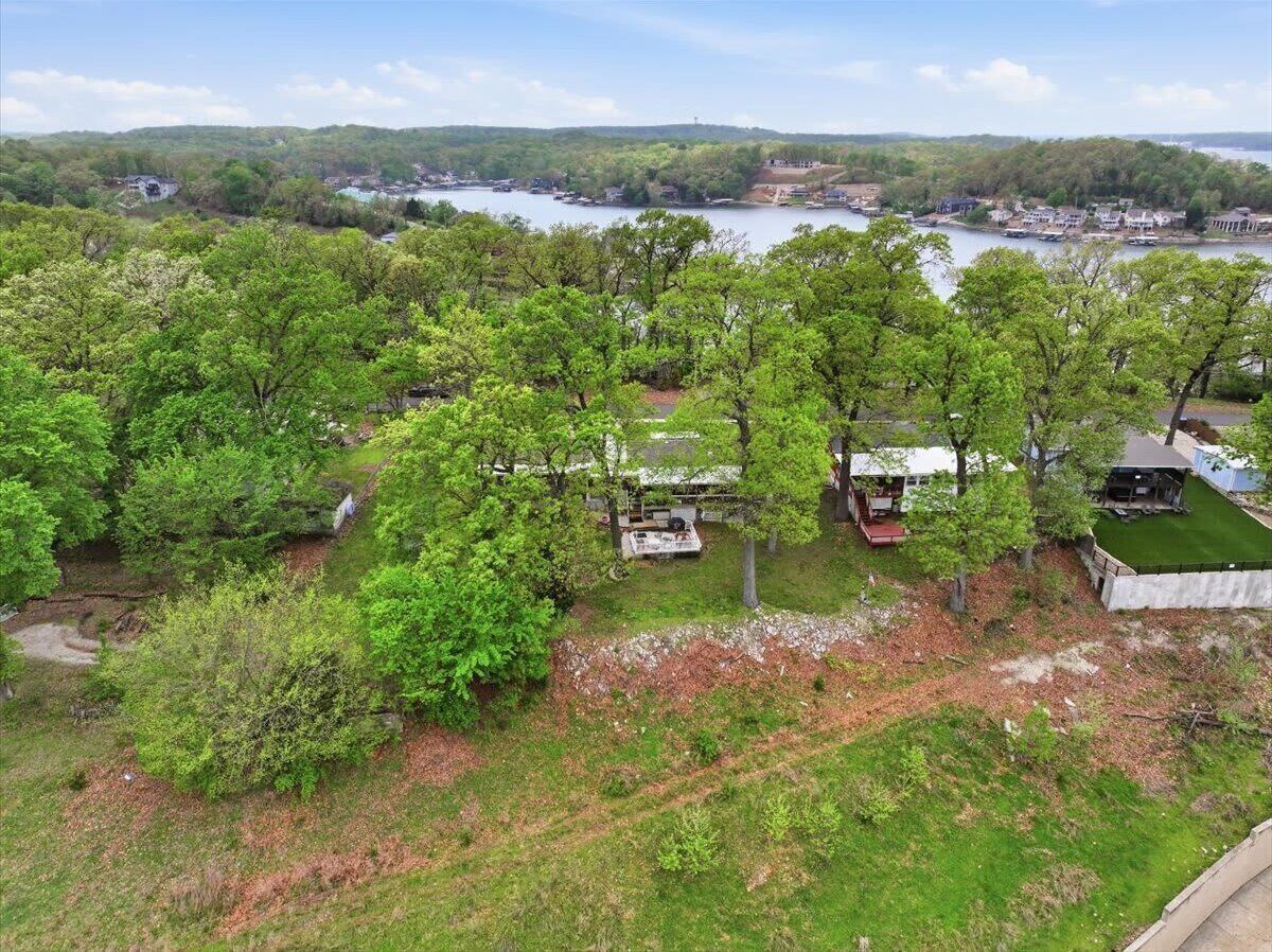 A residential area with a house, a small deck, and a view of a lake.