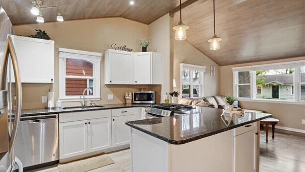 A kitchen with white cabinets, a central island, stainless steel appliances, and pendant lighting. - Perfect Lake Escape Near Bagnell Dam Strip (Lake Ozark)