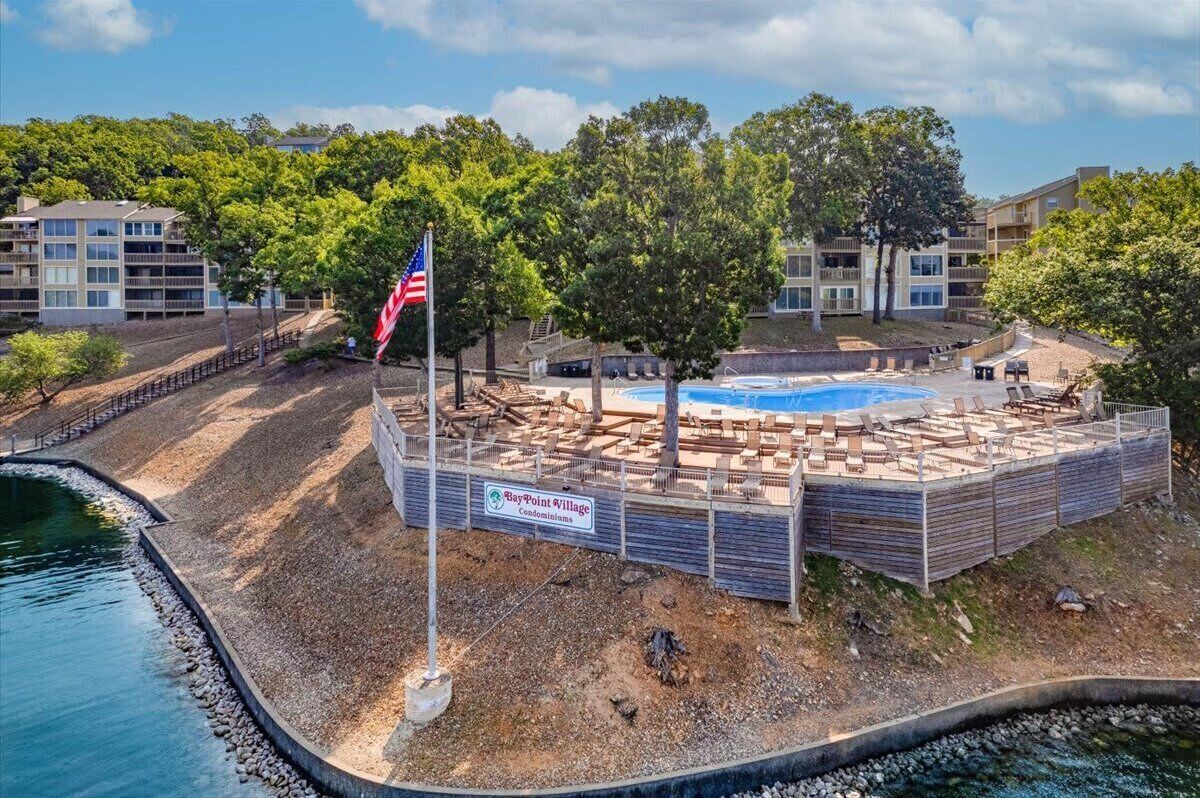 A residential area with a swimming pool, a flag, and a sign for BayPoint Village Condominiums.