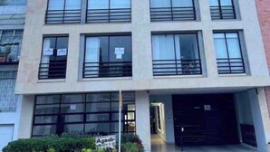 A multi-story building with large windows, a flat facade, and a visible entrance. - DUPLEX ROOF CHAPINERO ALTO (Bogotá)