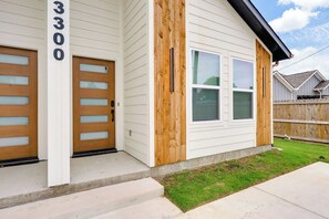 Ein zweistöckiges Haus mit Garage, Eingangstür und einer Wand aus Holzlamellen.