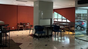 Un intérieur moderne avec un espace salon, une grande colonne et une vue à travers un mur de verre.