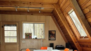 Ein Essbereich mit Tisch, Stühlen und einer Decke mit Holzbalken.