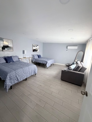A hotel room with two beds, a sofa, a lamp, and a mirror. - Spacious 4-bedroom house in amazing Phoenix with cool AC and Pool (Phoenix)