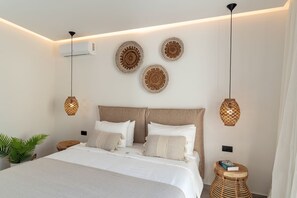 Une chambre moderne avec un grand lit, des tables de chevet, une plante en pot et des éléments de décoration fixés au mur.