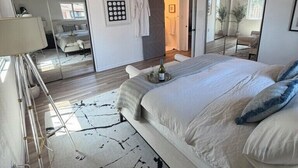 Una camera da letto con un letto grande, uno specchio, un comodino e un armadio.