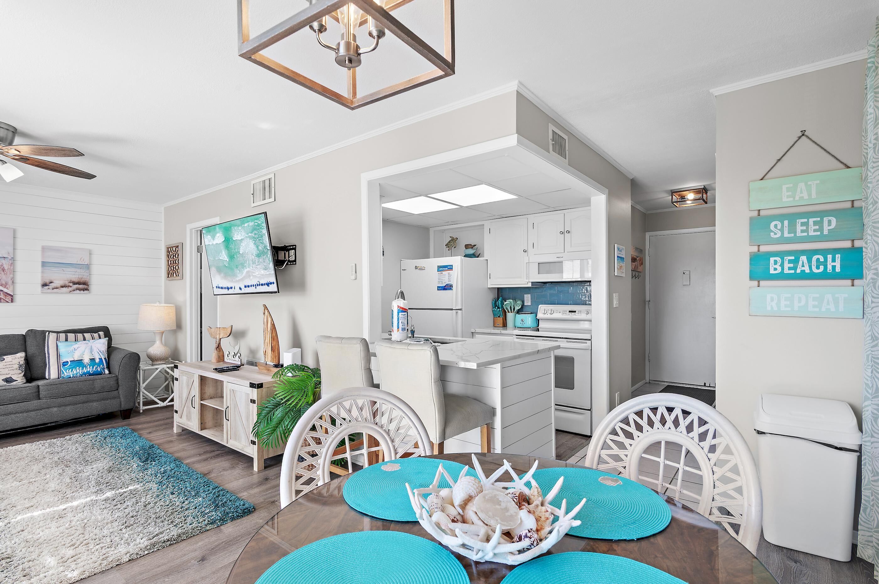 A modern living room with a sofa, dining table, and kitchen area.