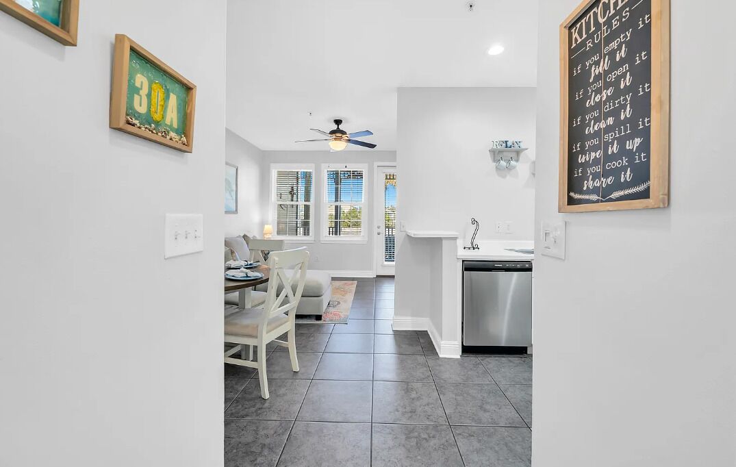 Cucina con lavastoviglie, zona pranzo con tavolo e sedie e ventilatore a soffitto.
