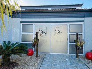 A hotel entrance with a modern design, featuring two large glass doors with the number '5' and 'FIFTY Boutique Hotel & Spa' written on them. - 50 Boutique Hotel and Spa (Port Elizabeth)