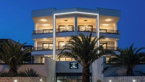 Un hotel de varios pisos con balcones, fachada de piedra y un cartel que indica que es un hotel en Zadar.