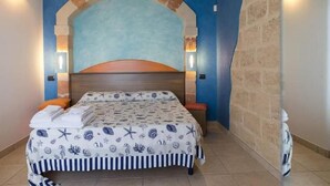 Une chambre à coucher avec un lit, une tête de lit et deux lampes fixées au mur.