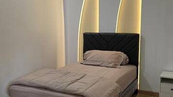 Quarto com cama, mesa de cabeceira e ar condicionado na parede.