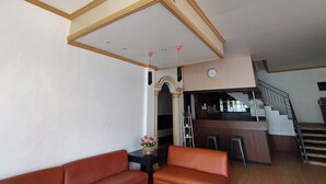 A hotel lobby with a staircase, a reception desk, and a seating area.