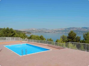 Ein Schwimmbad mit Blick auf einen See und Berge.