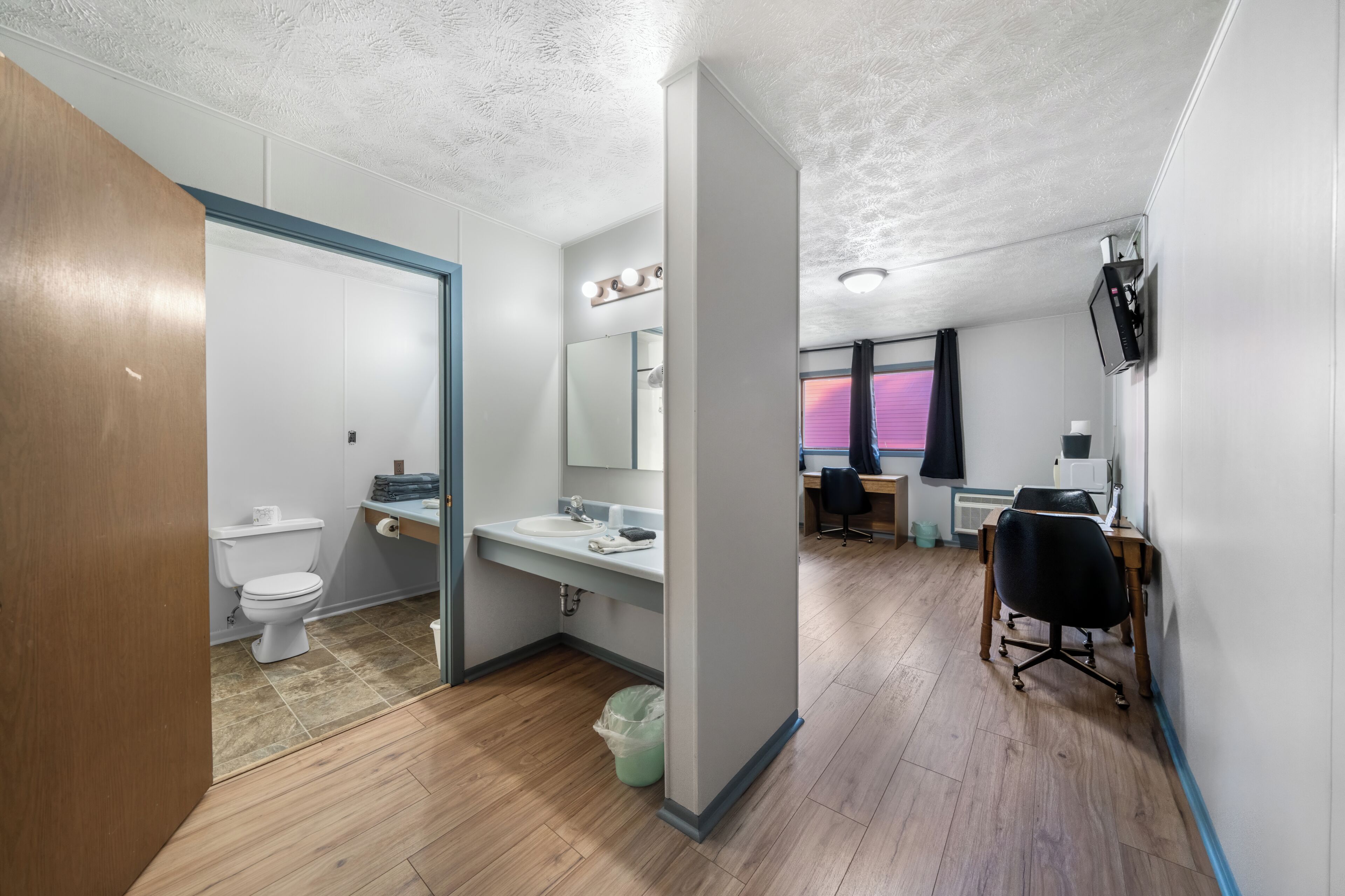 A modern bathroom with a toilet, sink, and mirror.