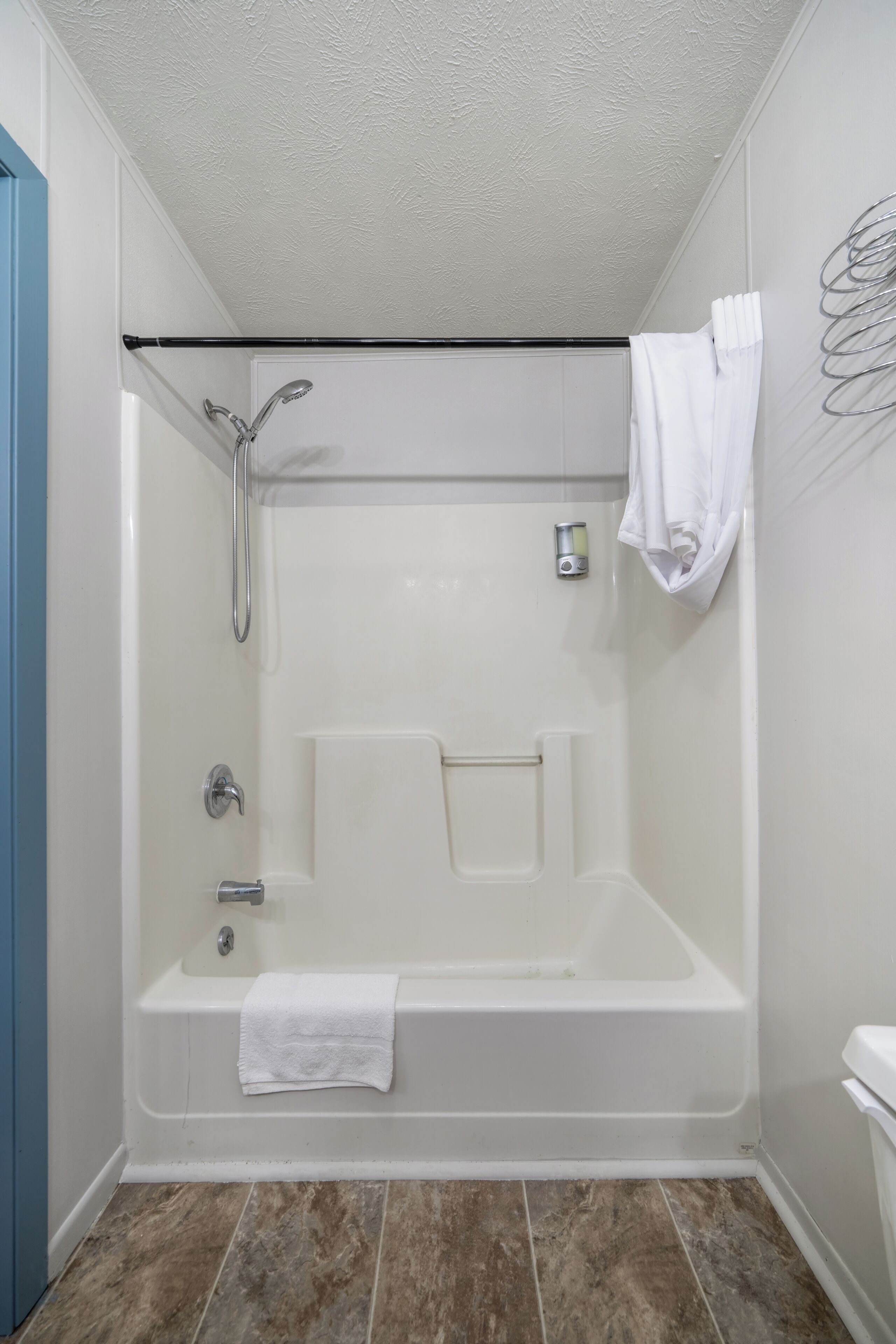 A modern bathroom with a bathtub, shower, and toilet.