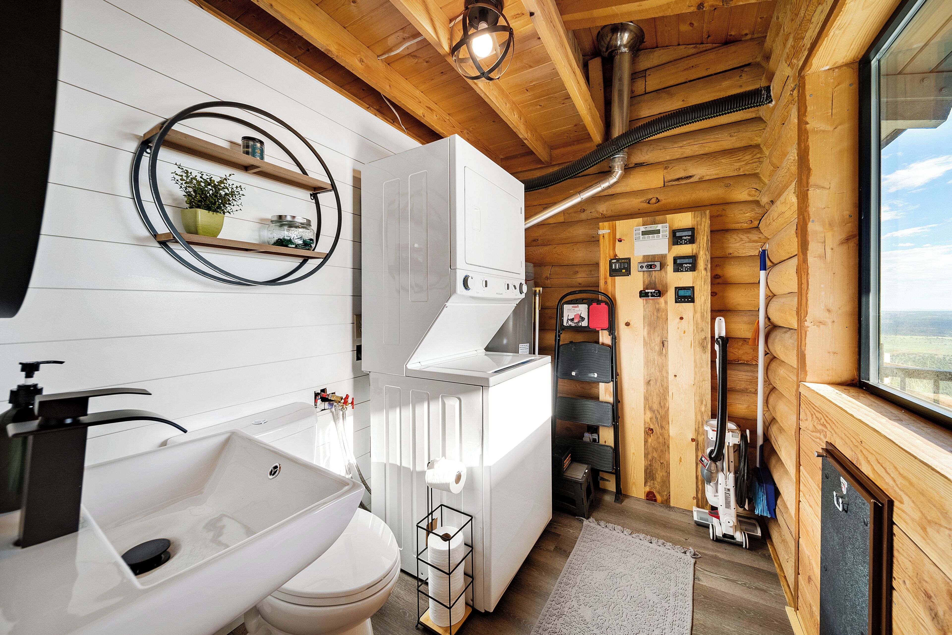 Un baño moderno y funcional con inodoro, lavamanos y lavadora integrada.