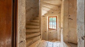 Una scala in pietra conduce a una finestra che si affaccia all'esterno.