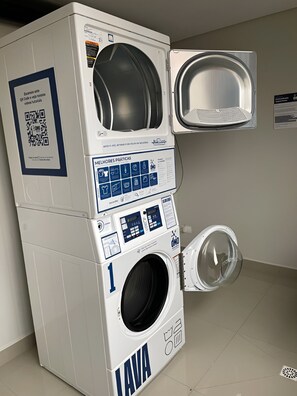 Un lave-linge à chargement frontal doté d’un panneau de commande, d’un code QR et d’un manuel d’utilisation.