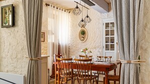 Un comedor con mesa de madera, sillas e iluminación colgante.