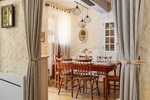 Un comedor con mesa de madera, sillas e iluminación colgante.