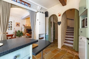 Una cocina con encimera, armarios y una escalera que lleva a otra habitación.