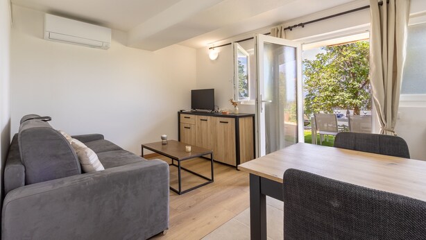 Una sala moderna con un sofá, una mesa de comedor y un televisor.
