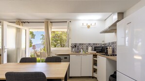 Una cocina compacta con comedor, vistas por la ventana y horno empotrado.