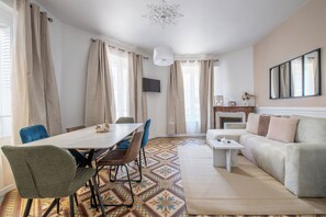 Un soggiorno moderno con zona pranzo, divano, televisore e camino.