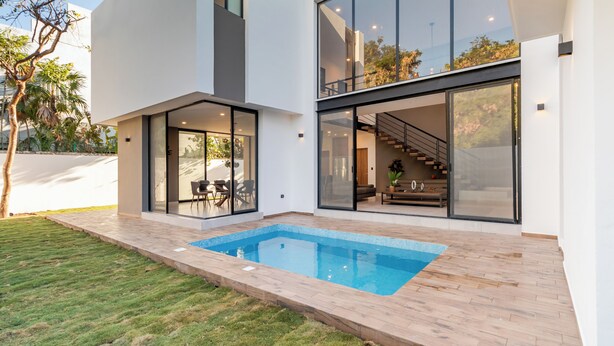A modern house with a swimming pool, large glass windows, and a staircase leading to an upper level. - Casa Brisa, Playa del Carmen (Playa del Carmen)
