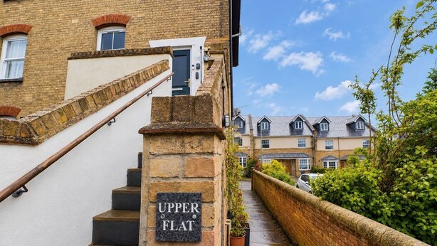 A narrow pathway leading to a residential building with a stone staircase and a sign reading 'Upper Flat.' - Charming, spacious and full of natural light 2-story flat in central Saxmundham. (Saxmundham)